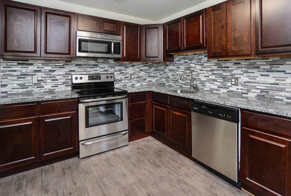 Contemporary kitchen with tile backsplash and espresso cabinets at Place One Apartment Homes in Plymouth Meeting, Pennsylvania