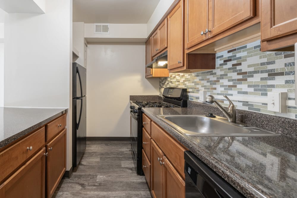 Kitchen with maple cabinets and tile backsplash at The Cascades Townhomes and Apartments in Pittsburgh, Pennsylvania