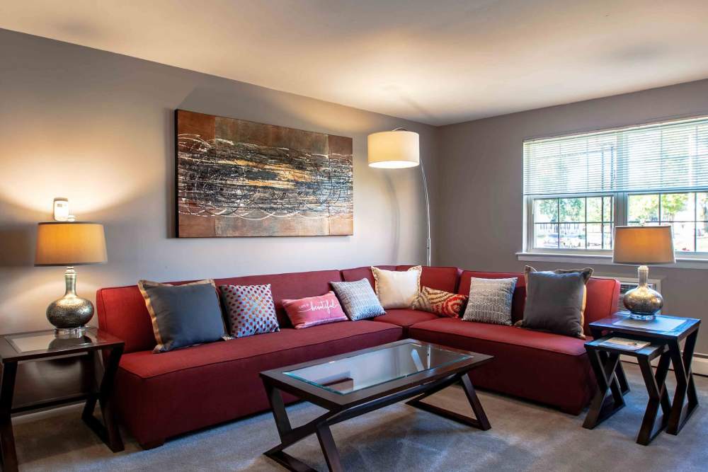 Living room with wrap around couch and large window at Camp Hill Plaza Apartment Homes in Camp Hill, Pennsylvania