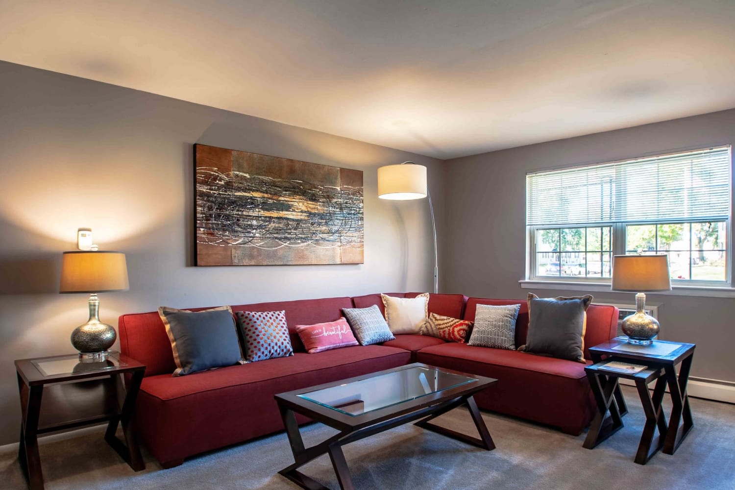 Living room with wrap around couch and large window at Camp Hill Plaza Apartment Homes in Camp Hill, Pennsylvania