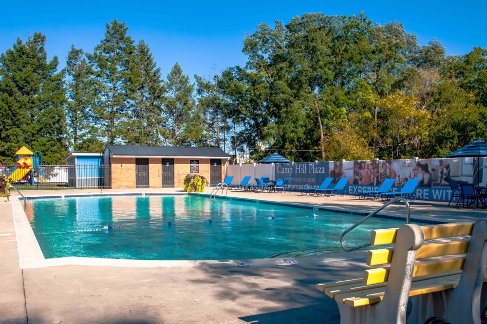 Pool with patio chairs at Camp Hill Plaza Apartment Homes in Camp Hill, Pennsylvania