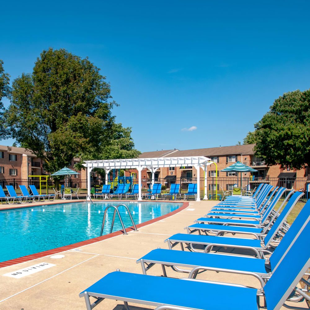 Swimming pool surrounded by lounge chairs at Chesterfield Apartment Homes in Levittown, Pennsylvania