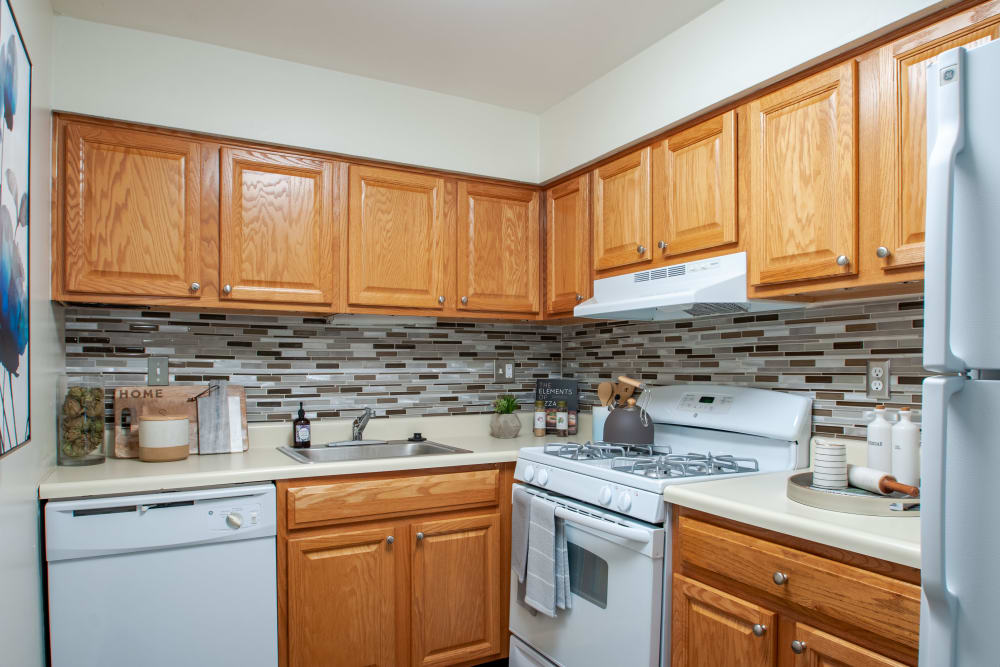 Kitchen with white appliances and tile backsplash at Chesterfield Apartment Homes in Levittown, Pennsylvania