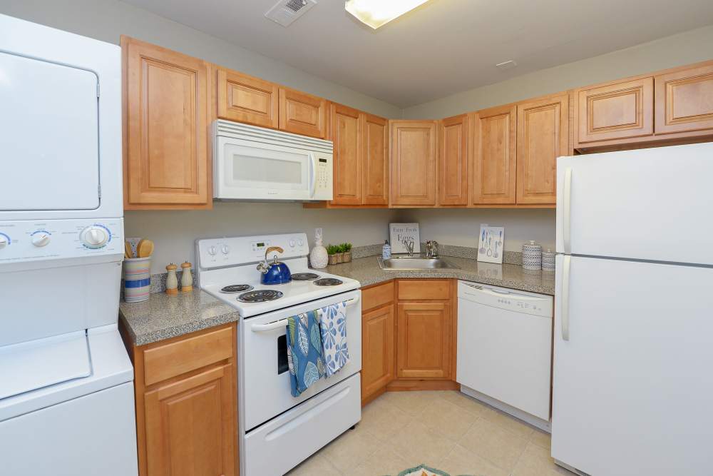 Kitchen with white appliances and oak cabinets at Lumberton Apartment Homes in Lumberton, New Jersey