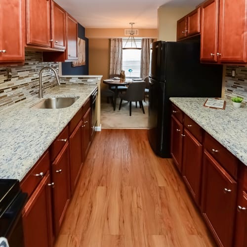 Open concept model kitchen with faux wood flooring at Montgomery Manor Apartments & Townhomes in Hatfield, Pennsylvania