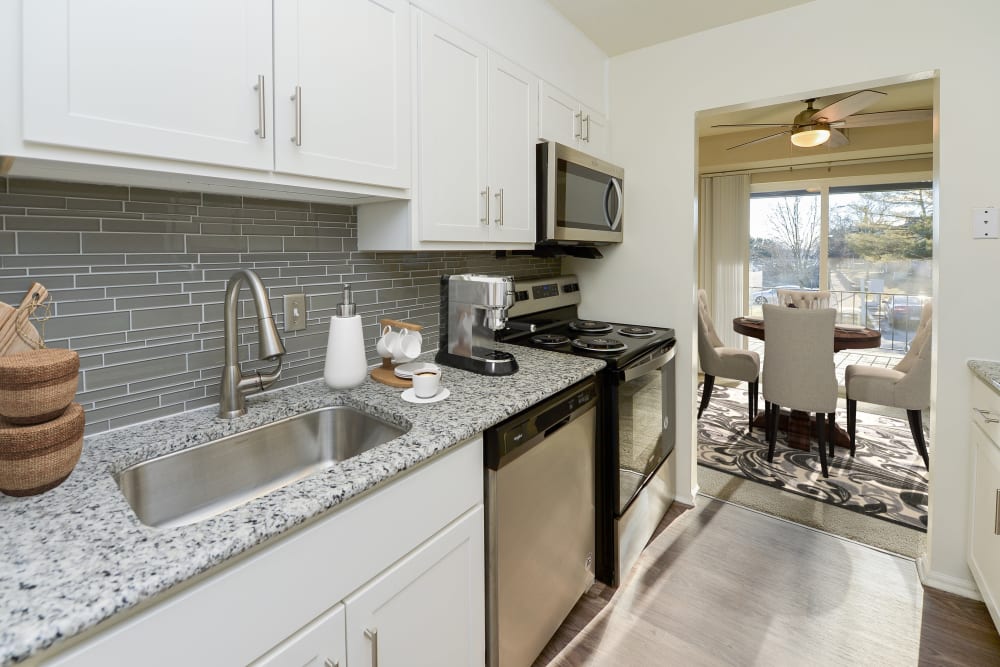 Contemporary kitchen with white cabinetry and tile backsplash at King's Manor Apartments in Harrisburg, Pennsylvania