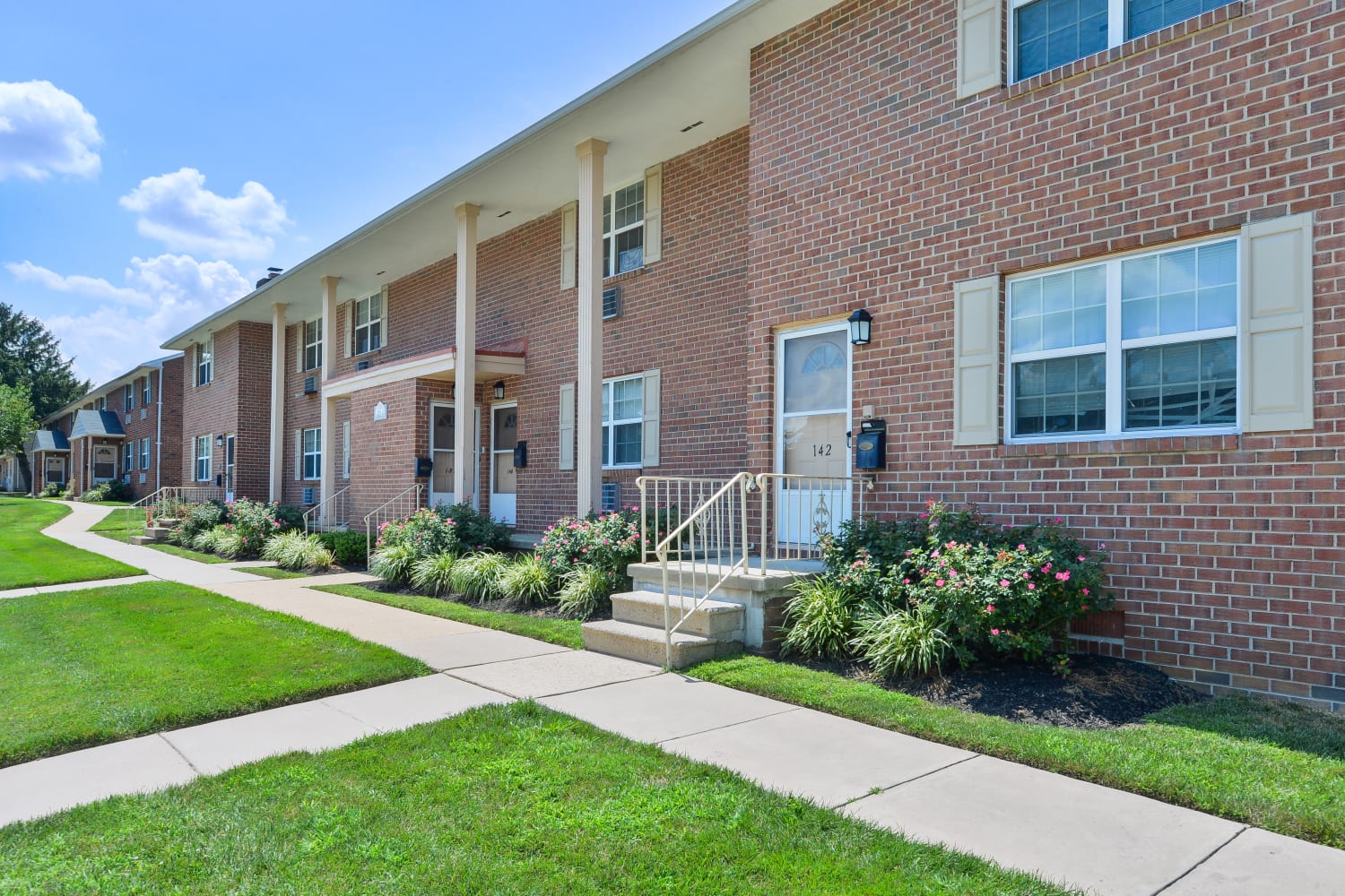 Apartment exterior with well-manicured lawn at Roberts Mill Apartments & Townhomes in Maple Shade, New Jersey