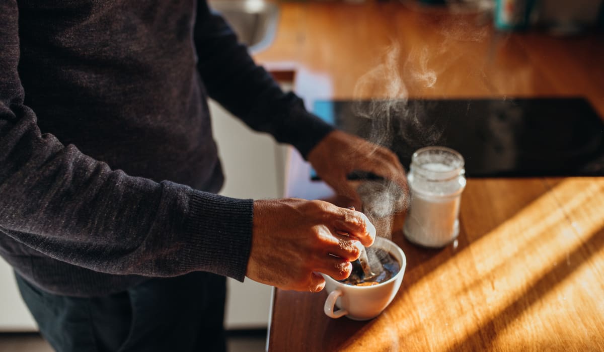 Resident making coffee in their modern kitchen at Silver Spring Station Apartment Homes in Baltimore, Maryland 