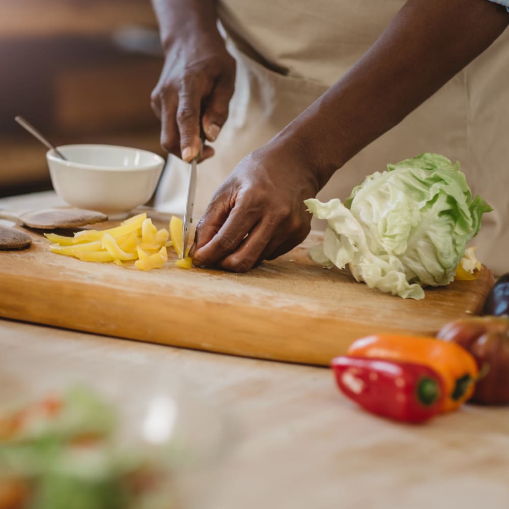 Resident chopping vegetables in their fully-equipped designer kitchen at Montgomery Woods Townhomes in Harleysville, Pennsylvania