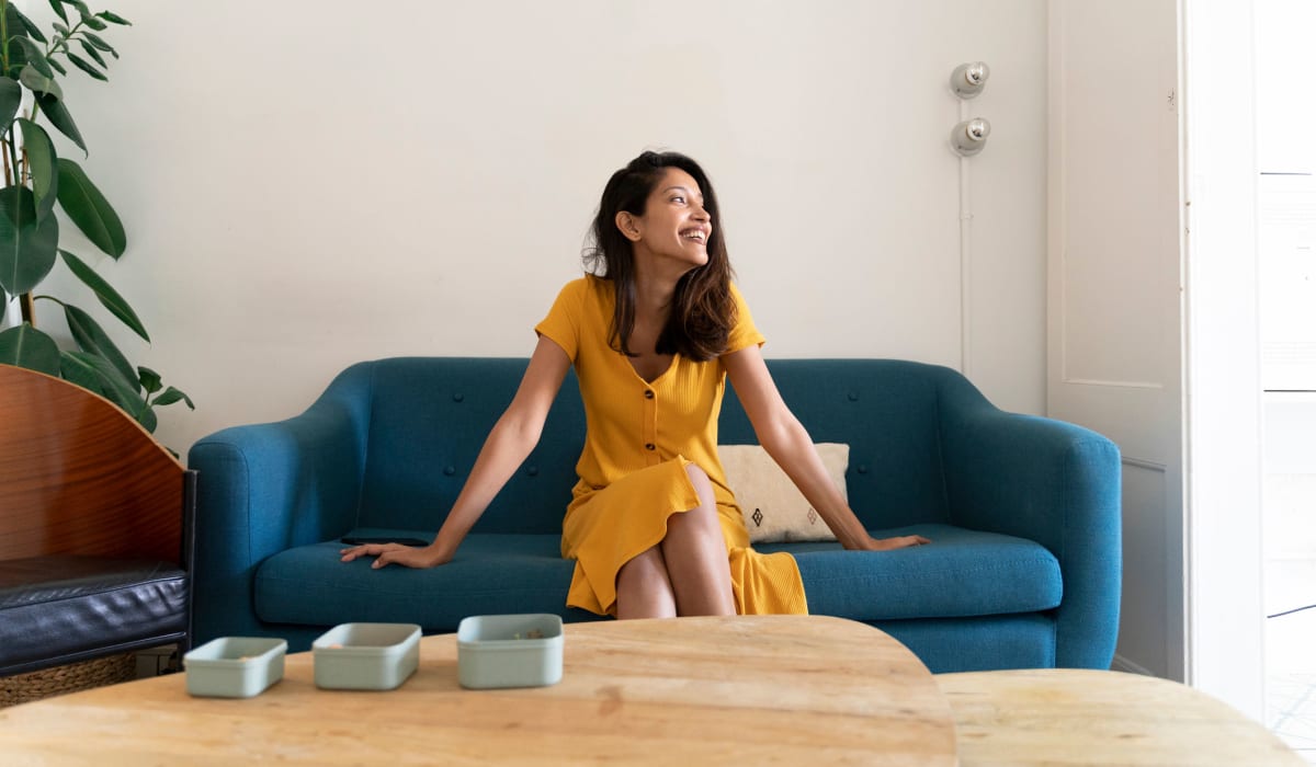 Resident relaxing in the living room of her new home at Park West 205 Apartment Homes in Pittsburgh, Pennsylvania