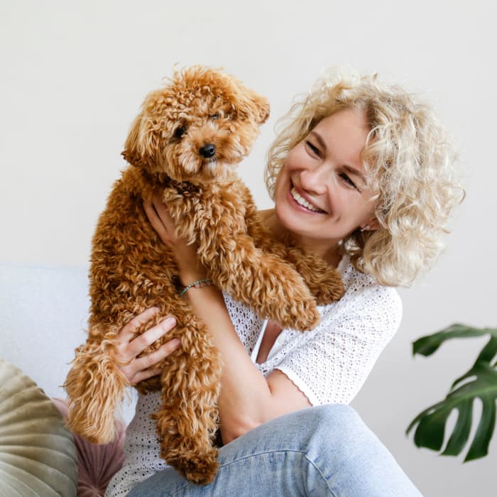 Resident spending time with her puppy in their pet-friendly home at Christopher Wren Apartments & Townhomes in Wexford, Pennsylvania
