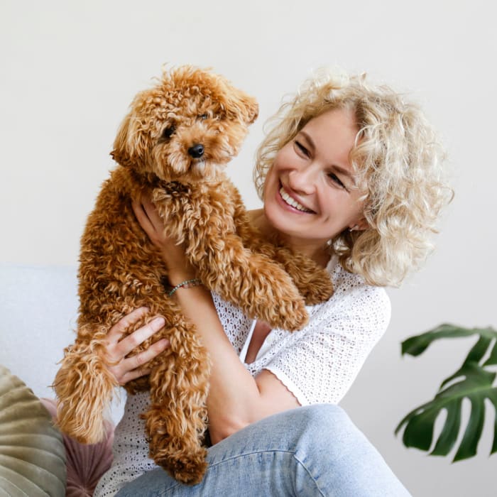 A resident holding a dog in a home at Highlands of Montour Run in Coraopolis, Pennsylvania