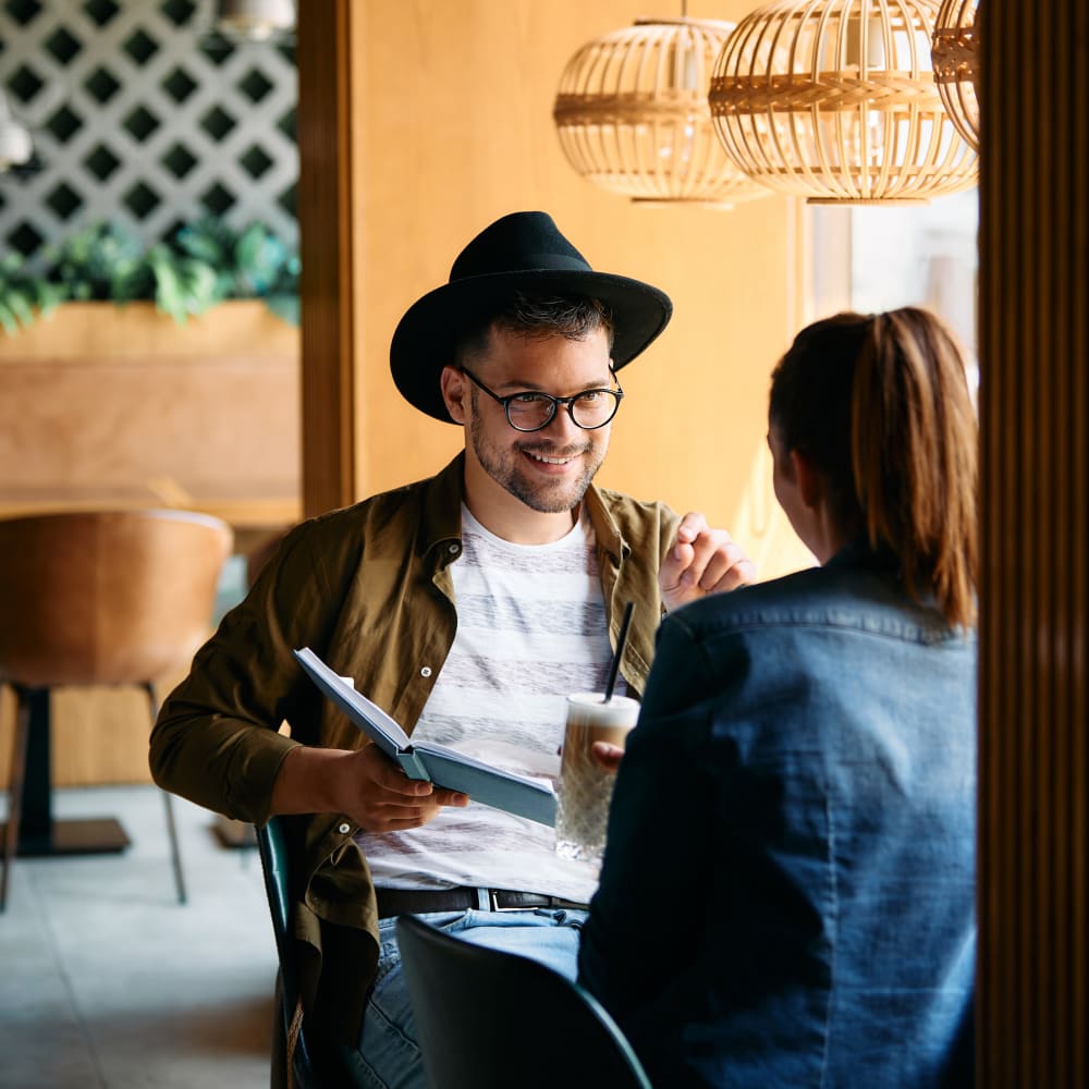 Residents chatting and reading in a modern cafe near Mapleton Square Apartment Homes in Dover, Delaware