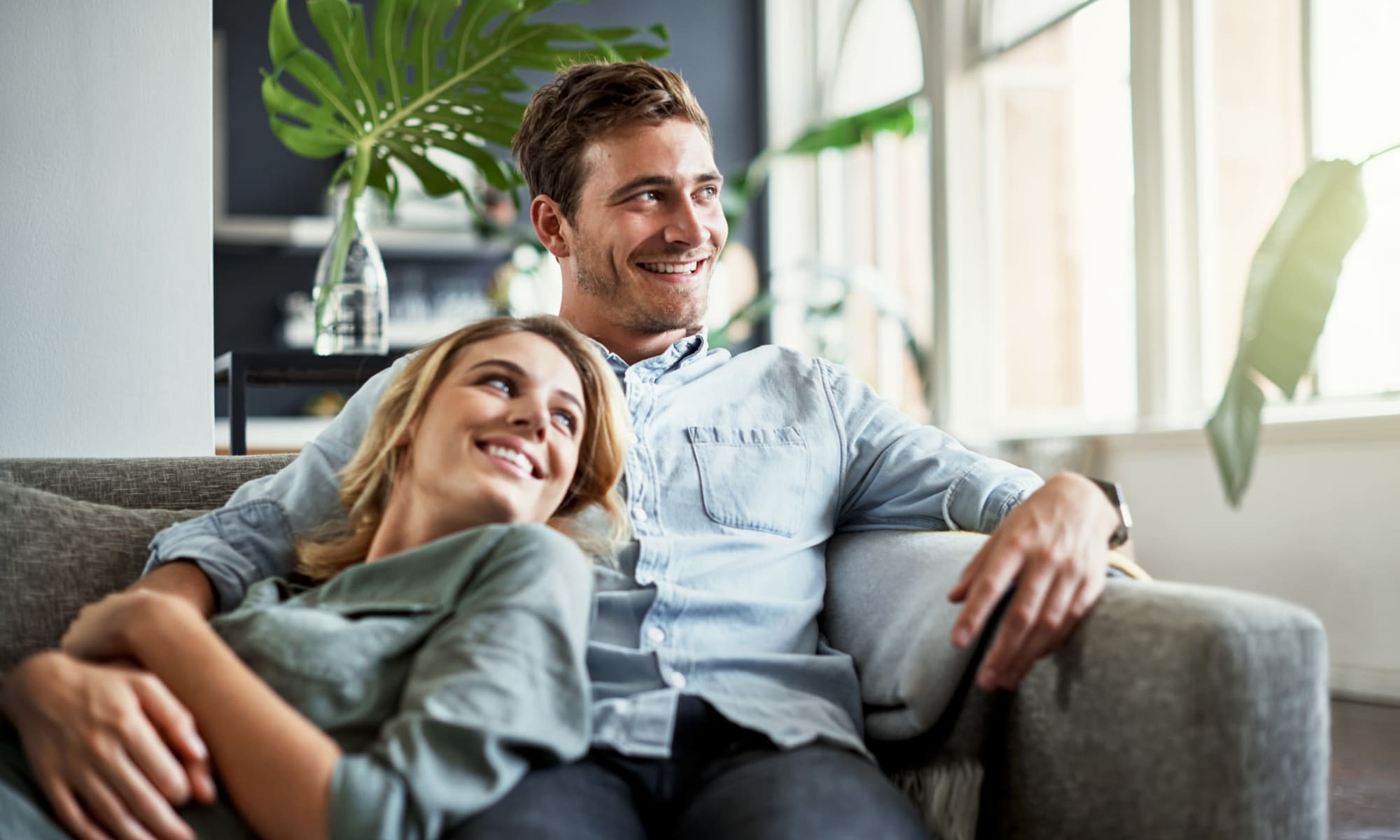 Resident couple relaxing on the couch in their apartment at Mews at Annandale Townhomes in Annandale, New Jersey