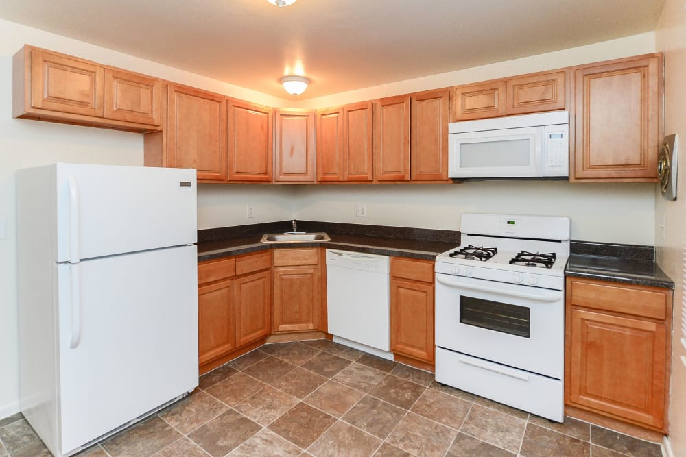 Kitchen with white appliances at Woodcrest Apartment Homes in Dover, Delaware