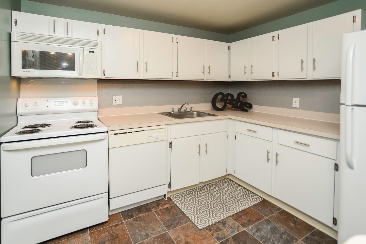 Kitchen with white cabinetry and appliances at Greentree Village Townhomes in Lebanon, Pennsylvania