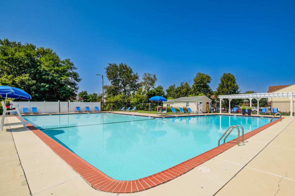 Swimming pool surrounded by lounge chairs at Lumberton Apartment Homes in Lumberton, New Jersey