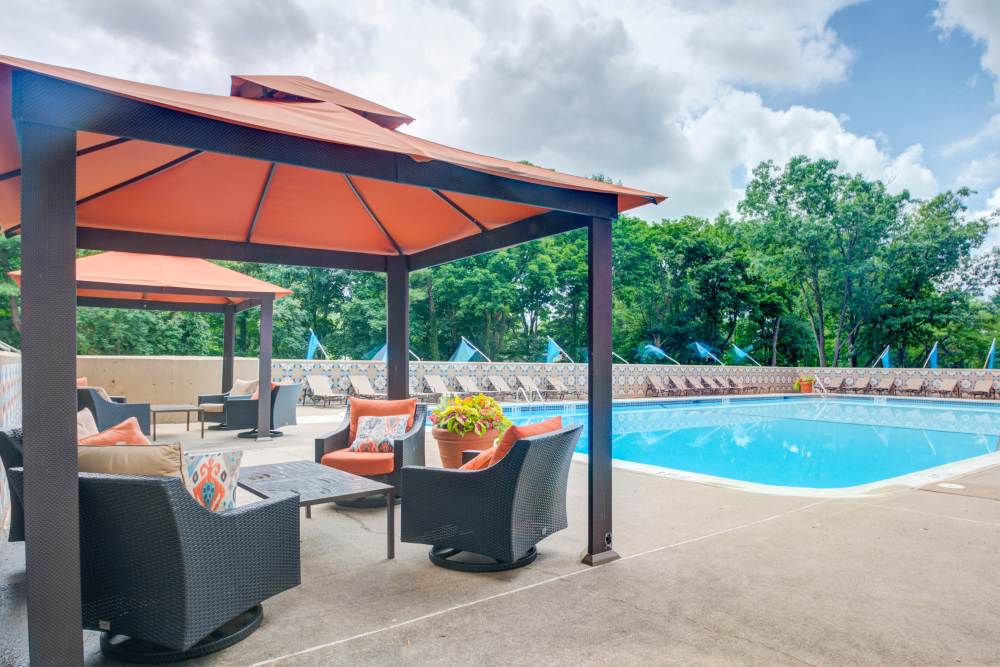 Swimming pool and sundeck with covered seating at Place One Apartment Homes in Plymouth Meeting, Pennsylvania