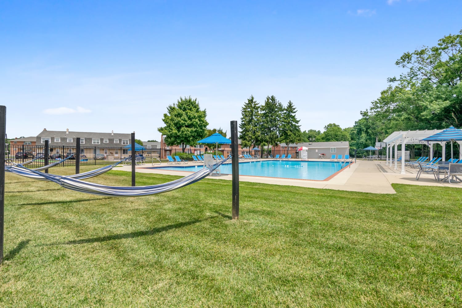 Outdoor swimming pool lounge area with hammocks at Roberts Mill Apartments & Townhomes in Maple Shade, New Jersey