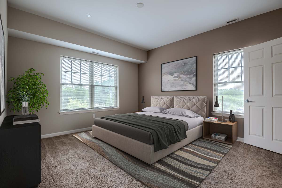 Staged bedroom with carpeting at Rochester Village Apartments at Park Place in Cranberry Township, Pennsylvania