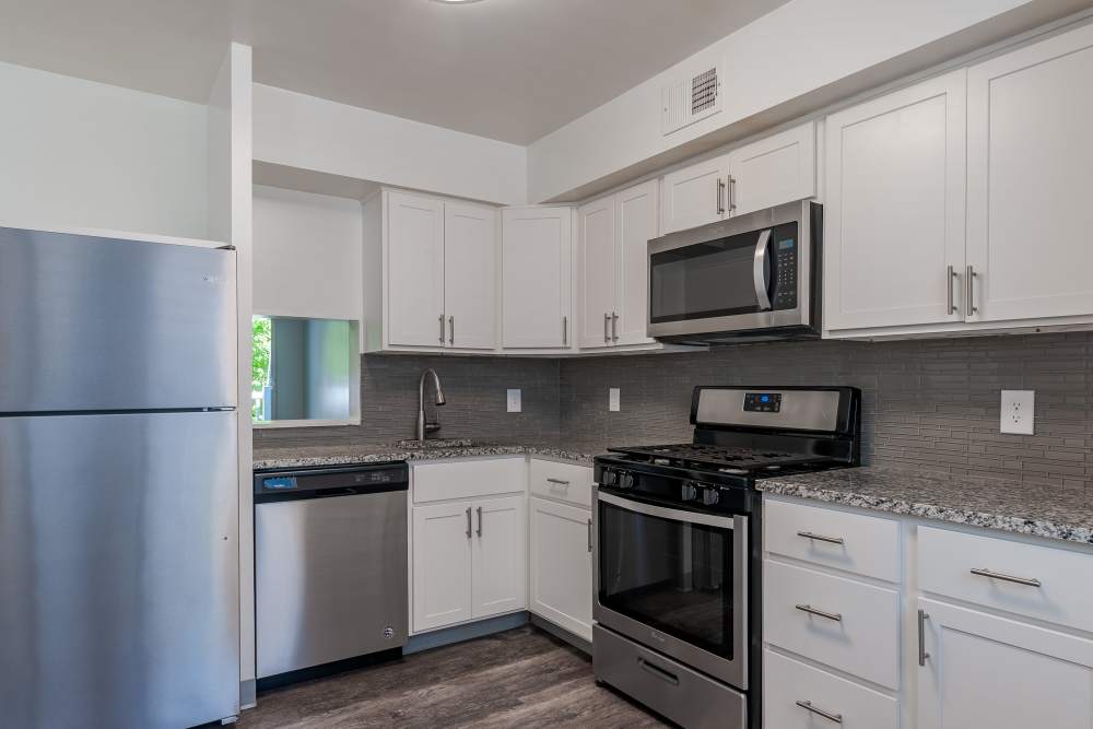 kitchen with white cabinets, granite countertops, and stainless steel appliances