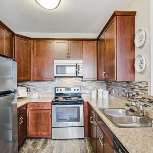 Modern kitchen with stainless steel appliances at Village at Potomac Falls Apartment Homes in Sterling, Virginia