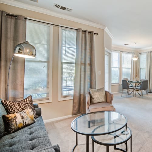Open concept model living room and kitchen at Village at Potomac Falls Apartment Homes in Sterling, Virginia