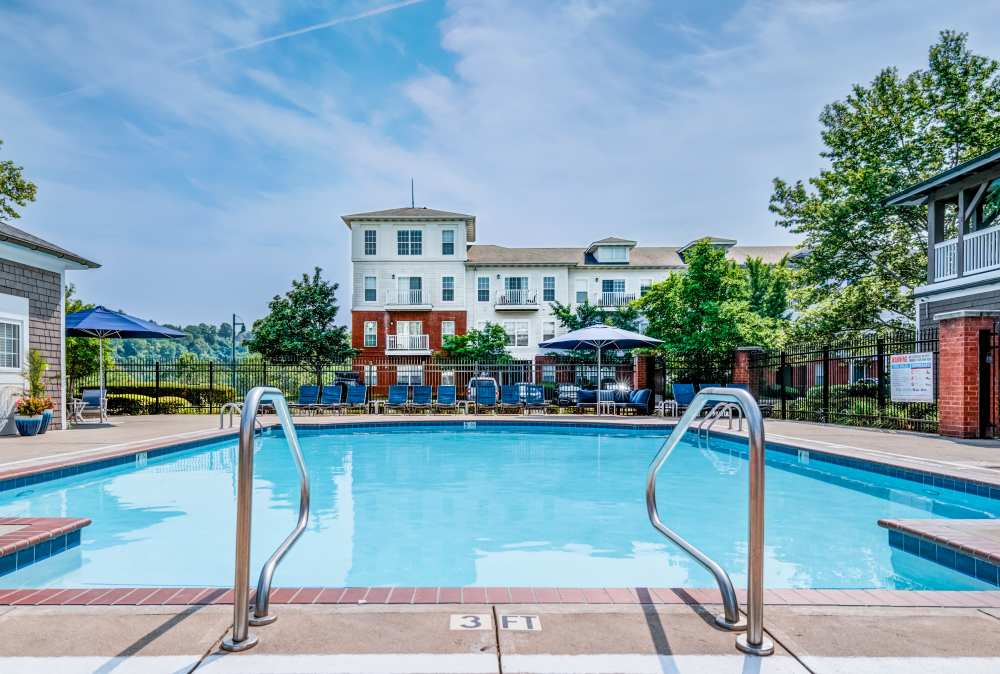Swimming pool and outdoor seating around at The Waterfront Apartments & Townhomes in Munhall, Pennsylvania