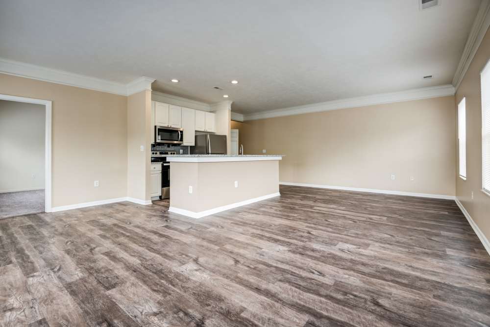 Open concept living room and kitchen with vinyl plank flooring at The Waterfront Apartments & Townhomes in Munhall, Pennsylvania