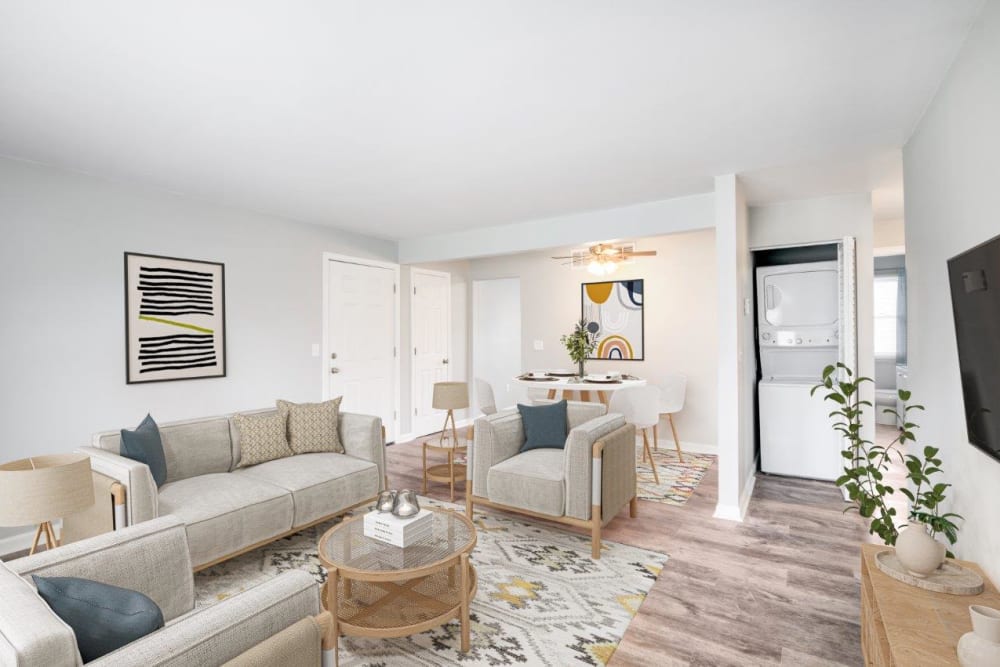 Staged living room with vinyl plank flooring and in-unit stacked laundry at Woodcrest Apartment Homes in Dover, Delaware